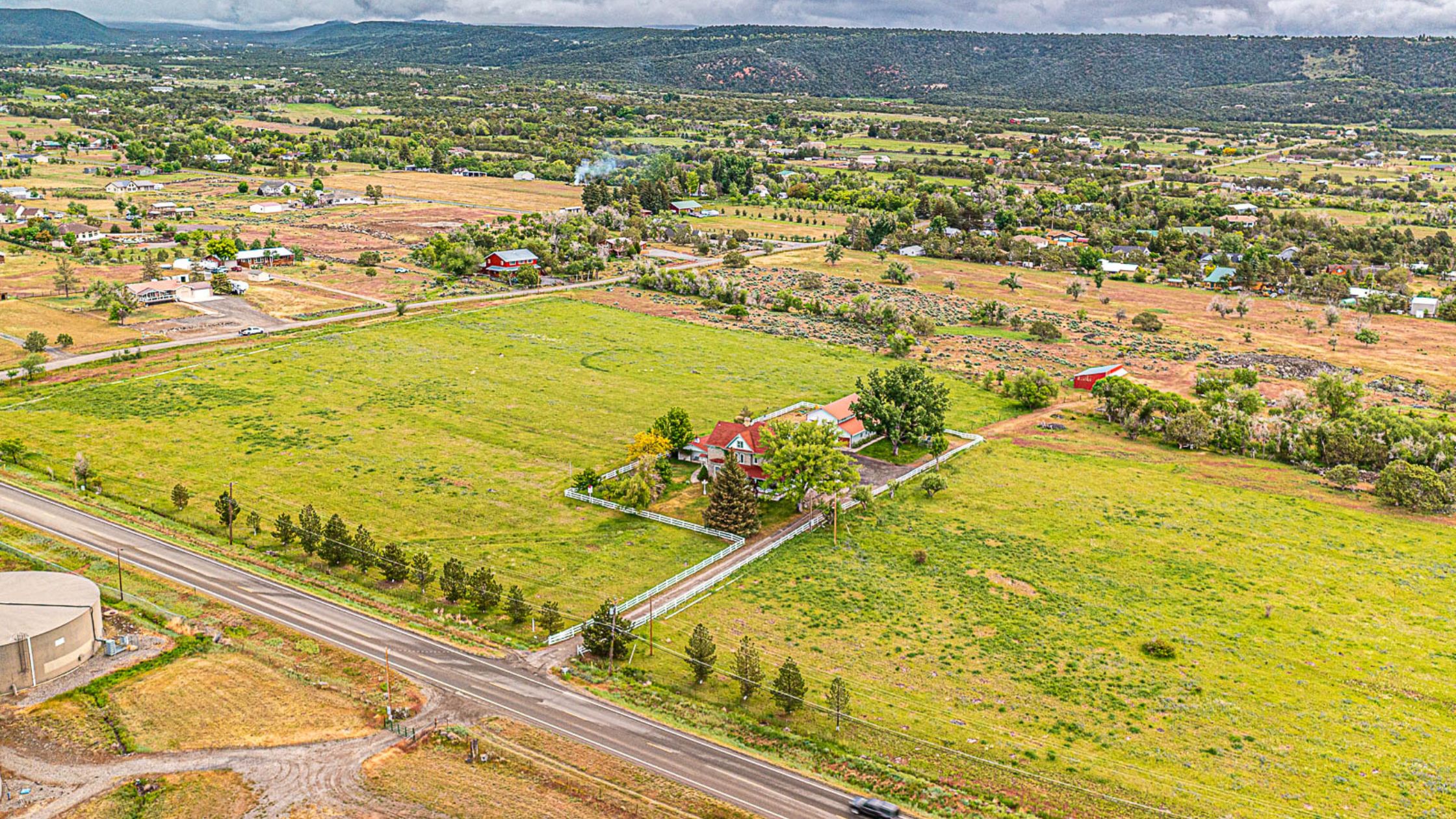 Aerial view of a historic estate surrounded by acres of green pastures, situated at the base of the Grand Mesa.