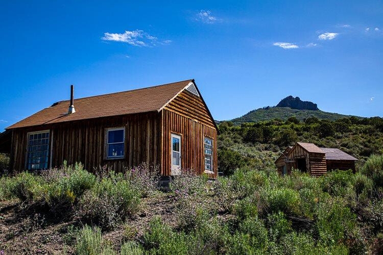 Crawford hunting cabin on 40-acre Colorado property, rustic off-grid home with mountain views and nearby outbuilding.
